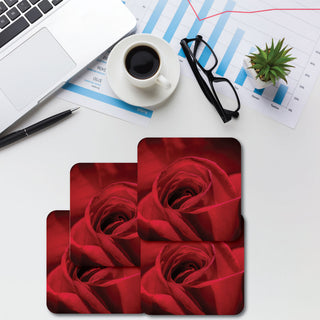 A set of four square coasters with a glitter finish pearl white color, displayed on a desk alongside a cup of coffee, glasses, and some office supplies.