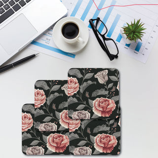 A set of four floral patterned coasters on a table with a cup of coffee, glasses, and some documents.